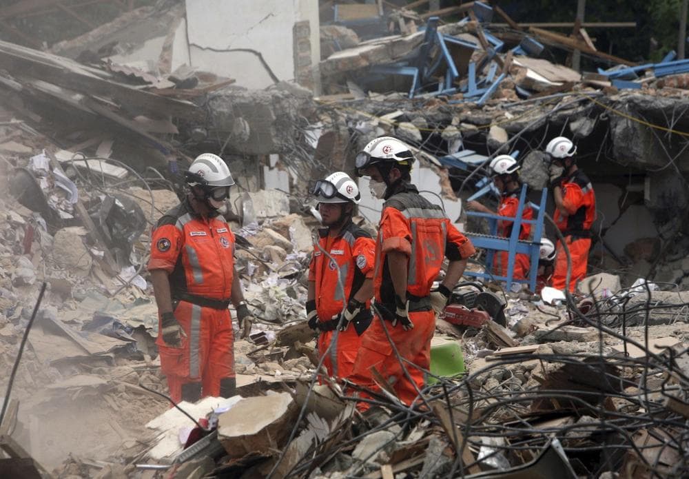 Swiss search and rescue personnel are seen amidst ruins from fallen buildings on Sunday in Padang, Indonesia, four days after Wednesday's 7.6-magnitude quake that toppled thousands of buildings on Sumatra island. (AP Photo/Achmad Ibrahim)