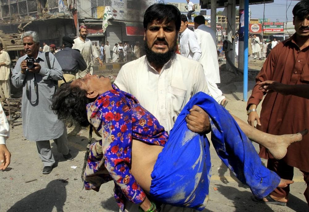 A man carries a woman injured by a bombing in Peshawar, Pakistan on Friday. A suicide car bomber detonated his vehicle along a road near a well-known market in Pakistan's northwest city of Peshawar on Friday, underscoring militants' ability to strike in major cities despite U.S.-backed military offensives pressuring their networks. (Mohammad Sajjad/AP)