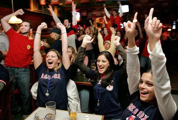 Red Sox fans, seated front from left, Jamie Hawley, Faryn Maya and Neela Samia, as the Boston Red Sox score in the first inning against the New York Yankees in American League playoff action on Wednesday, Oct. 20, 2004. (Steven Senne/AP)