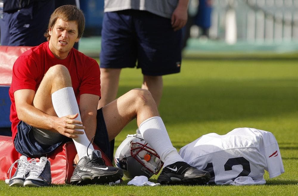 New England Patriots quarterback Tom Brady (12) puts his cleats on after taking the field at the  Oval Cricket Ground in London,  Friday afternoon. (AP/Stephan Savoia)