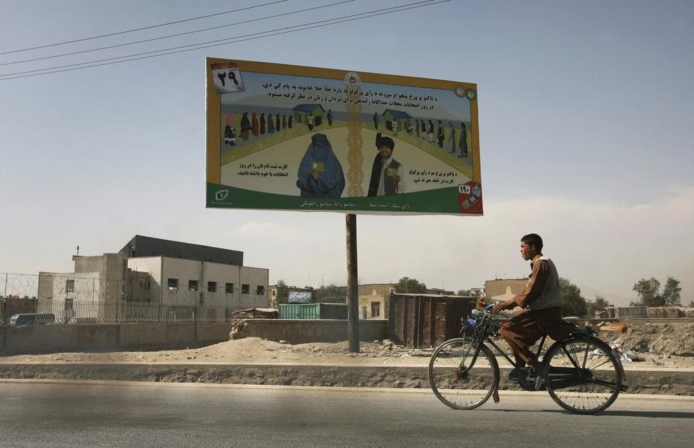 An Afghan youth rides his bike, passing by an election billboard that asks the people to vote, in Kabul, Afghanistan on Monday, Oct. 19, 2009. The Afghan electoral crisis intensified Monday as officials responsible for declaring final results from the August presidential ballot refused to accept findings of a U.N.-backed investigative panel that would force a runoff, those involved in the process said. (AP)