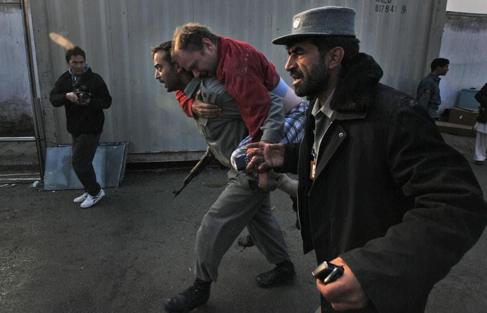 An Afghan policeman carries an injured unidentified German National, a U.N. staffer from the site of a attack in Kabul, Afghanistan on Wednesday, Oct. 28, 2009. Gunmen attacked a guest house used by U.N. staff in the Afghan capital of Kabul early Wednesday, officials said. A Taliban spokesman claimed responsibility, saying it was meant as an assault on the upcoming presidential election. (AP)