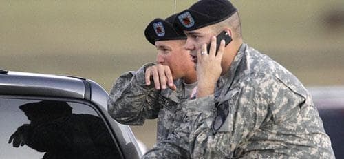 Spc. Ryan Howard of Niles, Mich., right and Spc. David Straub of Ardmore, Okla. wait for news of fellow soldiers while waiting at the gate of the Army base after a shooting at Fort Hood, Texas, Thursday, Nov. 5, 2009. (AP)
