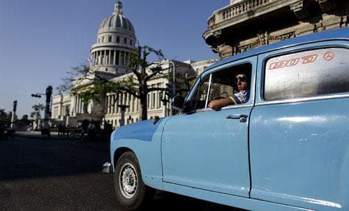 A driver waits for a green light next to the Cuban Capitol building in Havana, Wednesday, March 11, 2009. (AP)