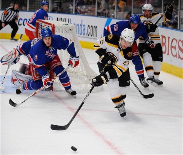 New York Rangers&#039; Dan Girardi (5) defends the goal as  Boston Bruins&#039; Mark Recchi (28) skates after the puck in the first period of the game on Sunday.  (Stephen Chernin/AP)