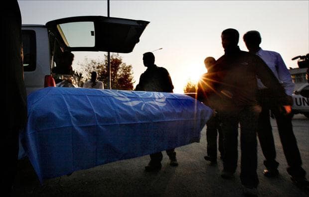 U.N. staff unload a coffin during a ceremony on Tuesday to transfer the remains of their two fellows who were killed when gunmen attacked a guest house. (Gemunu Amarasinghe/AP)