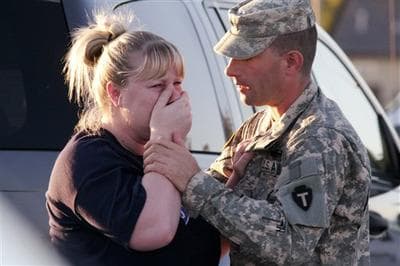 Sgt. Anthony Sills, right, comforted his wife as they waited outside the Fort Hood Army Base on Thursday. The Sills' 3-year old son was still in daycare on the base, which was locked down following a mass shooting earlier in the day. (Jack Plunkett/AP)