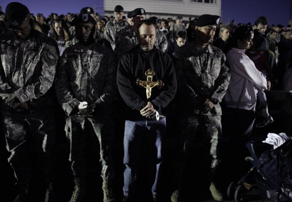 One carrying a cross, mourners pray during a vigil in Fort Hood, Texas on Friday,  in the wake of Thursday&#039;s shootings that killed 13 people on the base. (AP Photo/LM Otero)