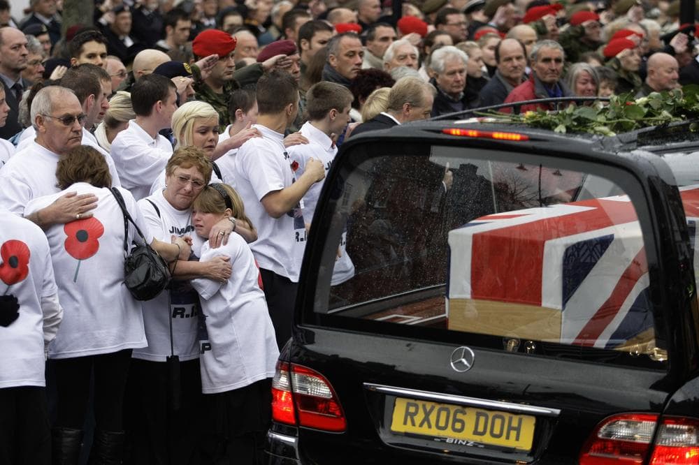 People react as the coffins of six British soldiers are driven through Wootton Bassett, England, after being repatriated at RAF Lyneham, Tuesday, Nov. 10, 2009.  Hundreds gathered in this small English market town Tuesday to pay tribute to six soldiers killed in Afghanistan, five of whom were shot to death by an Afghan police officer who turned against them.  (AP)