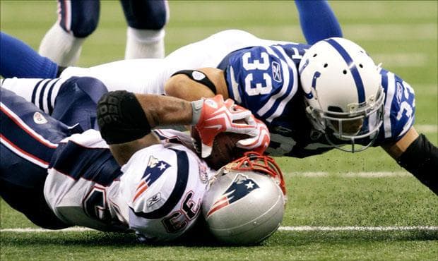 Patriots running back Kevin Faulk is tackled by Colts cornerback Melvin Bullitt on fourth down during the fourth quarter on Sunday. (AJ Mast/AP)