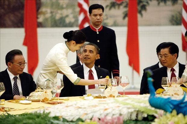 President Obama looks towards the server as he takes his seat during a State Dinner Reception with Chinese President Hu Jintao at the Great Hall of the People in Beijing. (Pablo Martinez Monsivais/AP)