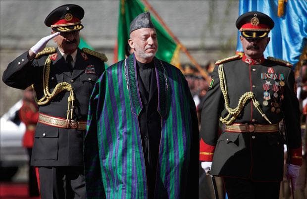 Afghanistan&#039;s President Hamid Karzai greets the guards of honor as he arrives to the Presidential Palace for his inauguration in Kabul. (Anja Niedringhaus/AP)