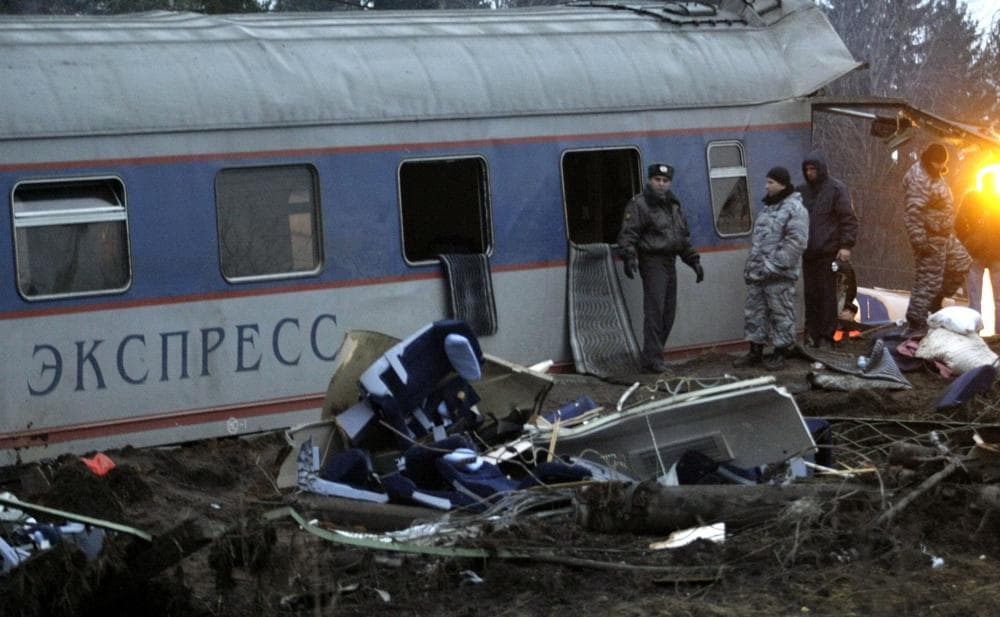 Russian police officers inspect a damaged coach at the site of a train derailment near the town of Uglovka, some 400 km (250 miles) north-east of Moscow, Russia on Saturday.  (AP Photo/Ivan Sekretarev)