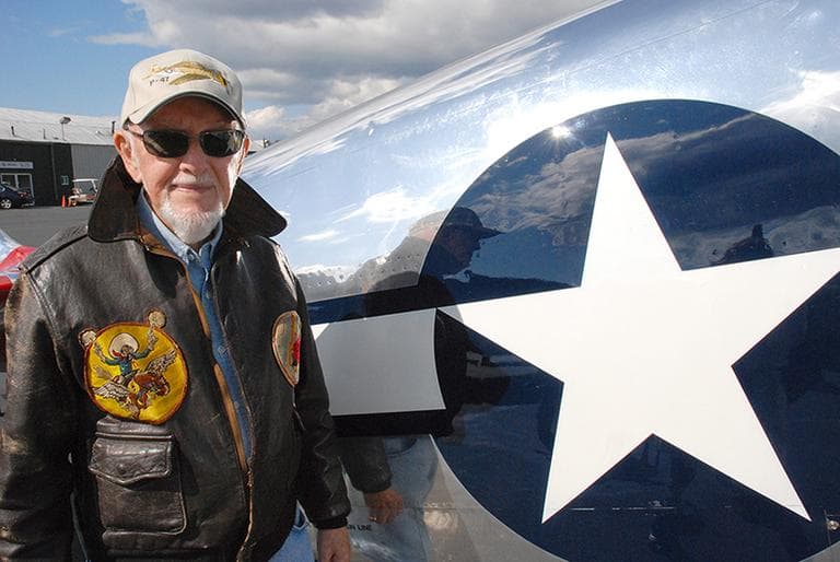 George Sutcliffe with a restored P-51 Mustang fighter plane in Norwood. (Sarah Bush/WBUR)