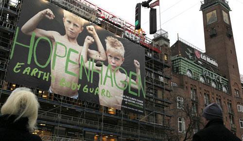 Pedestrians wait at a crossing opposite a poster reading &quot;Hopenhagen Earth Body Guard&quot; on a building in the center of Copenhagen, Denmark, on Sunday Dec. 6, 2009, one day before the Climate Summit begins. The poster urges people to sign the climate change petition. (AP)