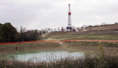 A drilling rig used to bore thousands of feet into the earth to extract natural gas from the Marcellus shale deep underground is seen on the hill above the pond on John Dunn's farm in Houston, Pa. Wednesday, Oct. 29, 2008. 