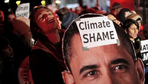 Demonstrators hold a picture of U.S. President Barack Obama during a demonstration outside the Bella Center, the venue of the U.N. Climate Conference in Copenhagen, Denmark, early Saturday, Dec. 19, 2009. (AP)