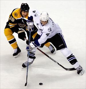 Bruins left wing Marco Sturm and Lightning center Vincent Lecavalier vie for the puck on Wednesday. (Elise Amendola/AP)