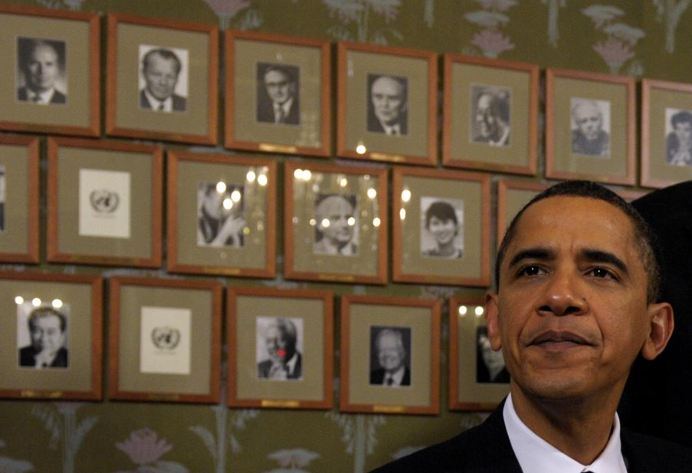 President Barack Obama sits in front of framed photos of previous Nobel Peace Prize winners during a Signing Ceremony at the Norwegian Nobel Institute in Oslo, Norway, Thursday, Dec. 10, 2009. (AP)