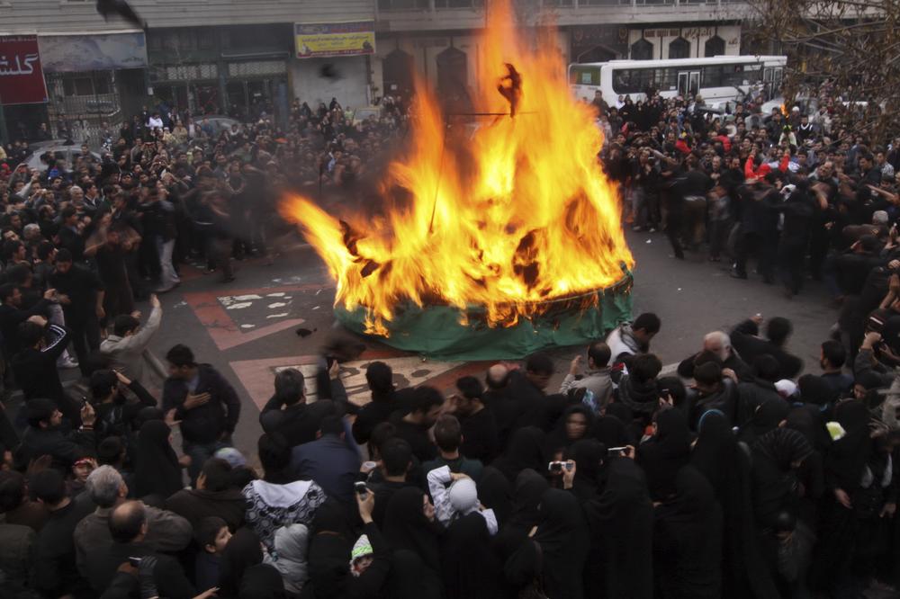 Iranian mourners attend a ceremony commemorating Shiites' holy day of Ashoura, in Tehran, Iran, Sunday, Dec. 27, 2009, marking the death of Imam Hussein, a grandson of Islam's prophet Mohammed, who was killed in a 680 A.D.in a battle at Karbala in Iraq.  Mourners burned a green tent, as a symbol of Imam Hussein's tent. (AP)