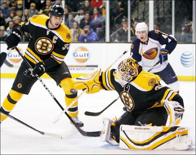 Boston Bruins&#039; Tim Thomas, center, blocks a shot as Zdeno Chara, left, of Slovakia, and Atlanta Thrashers&#039; Rich Peverley, right, look on in the first period of a game on Wednesday. (AP)