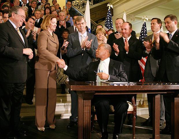 Massachusetts Gov. Deval Patrick, seated right, shakes Senate President Therese Murray&#039;s hand after signing an ethics bill on July 1, 2009, in Boston. Among state officials watching are Speaker of the House Robert DeLeo, left, and Secretary of State William Galvin, third from right. (AP)