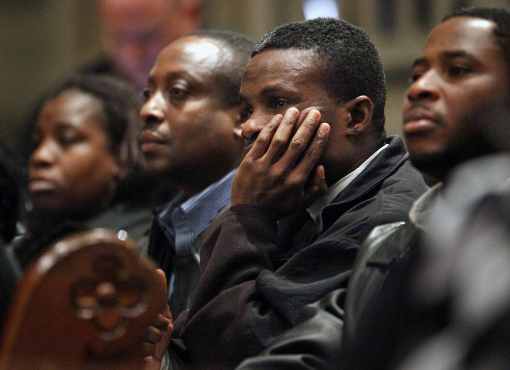 Patrick Casimir, second from right, a Medford resident born in Haiti, listens Wednesday during a meeting at the Cathedral of the Holy Cross in the South End held to update family members and spread information about relief efforts in the wake of the earthquake. (AP)