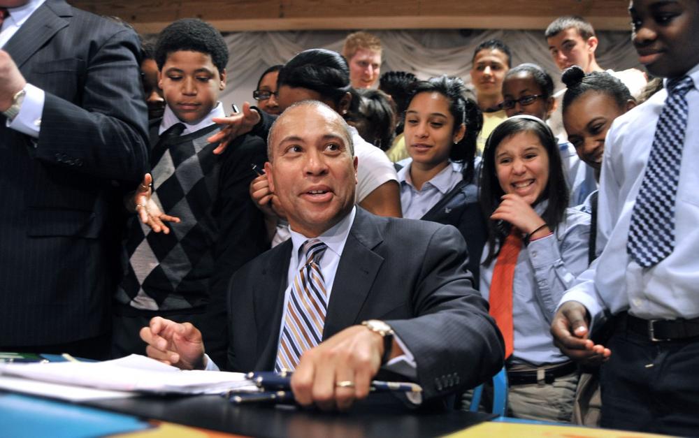 Gov. Deval Patrick gathers the pens used to sign the education reform bill as a group of Boston middle school students look on at the Children's Museum in Boston on Monday. (AP)