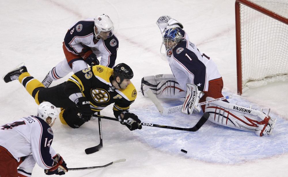 Boston Bruins defenseman Zdeno Chara (33), of Slovakia, dives toward the puck as Columbus Blue Jackets goalie Steve Mason, right, makes a save in the final seconds of the third period of Thursday&#39;s game (AP Photo/Charles Krupa).