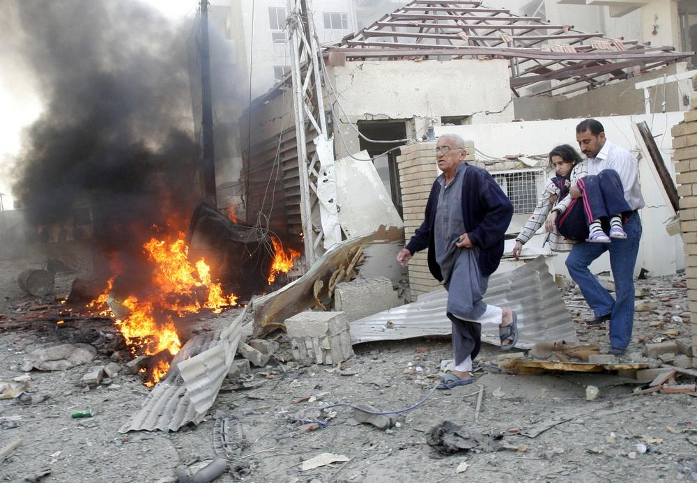 A family leaves their home after it was destroyed in one of three car bomb attacks in Baghdad on Monday. (AP)
