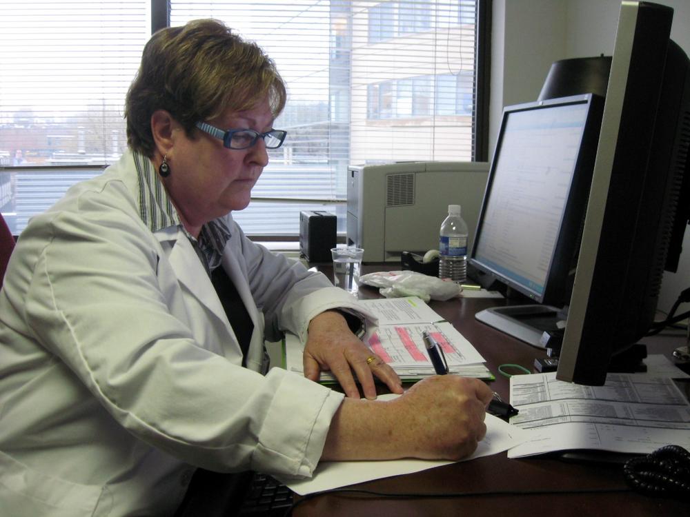 A nurse at Massachusetts General Hospital reviews medical records of a patient. (WBUR file photo)