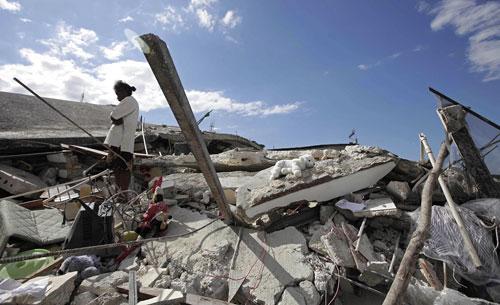 A woman stands in the rubble of her home the day after an earthquake hit Port-au-Prince, Haiti, on Wednesday, Jan. 13, 2010. (AP)