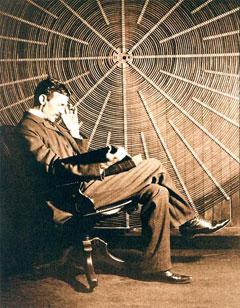 In this undated photograph, Nikola Tesla sits in front of the spiral coil of his high-voltage transformer at East Houston St., New York. (Wikimedia Commons)