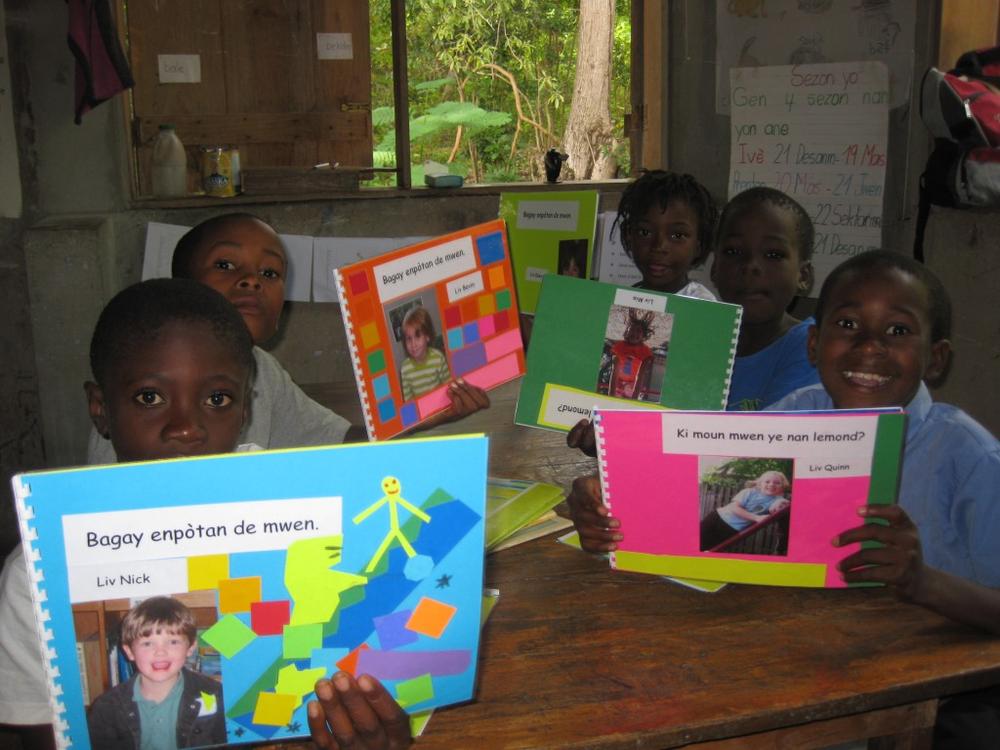Matenwa 1st and 2nd graders in Haiti with 'Mother Tongue Books' from Fayerweather Street School in Cambridge.