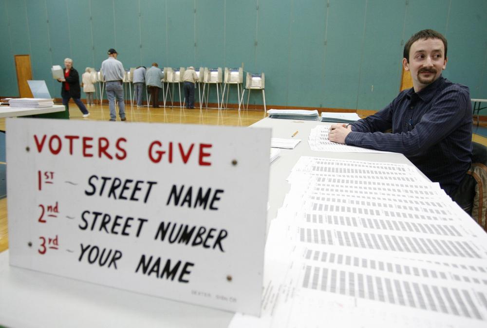 James Ostendorf, a pollster, waits to check in Massachusetts voters in Seekonk on Tuesday. (AP)