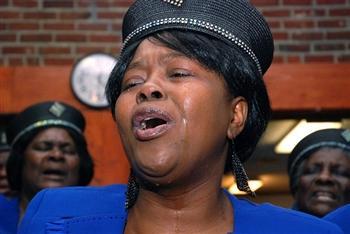 A woman cries as she sings at the Haitian Church of the Nazarene in Boston yesterday (Andrew Phelps/WBUR)