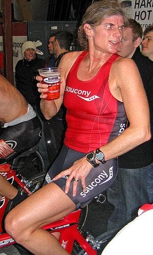 Karen Smyers enjoys a beer just moments after her &quot;Team Psycho&quot; won the team race at the Harpoon Indoor Time Trials. It was Smyers’ second ride on the simulated course. The 48-year-old Lincoln resident was also the top individual female rider.  (Doug Tribou/WBUR)