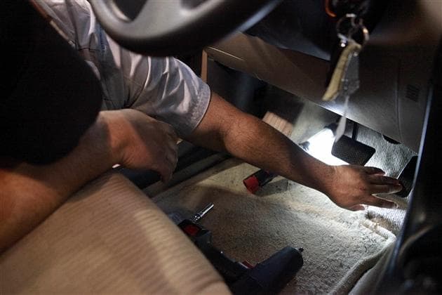 Toyota Technician Gene Cordero, of Boston, depresses the pedal of a repaired accelerator pedal assembly in a 2010 RAV4 at a  dealership in Norwood. (AP)