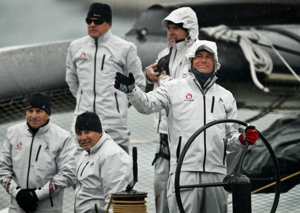 Alinghi owner Ernesto Bertarelli, right, waves from the Alinghi 5 boat as it&#39;s towed into Valencia&#39;s port, Feb. 8. (AP)