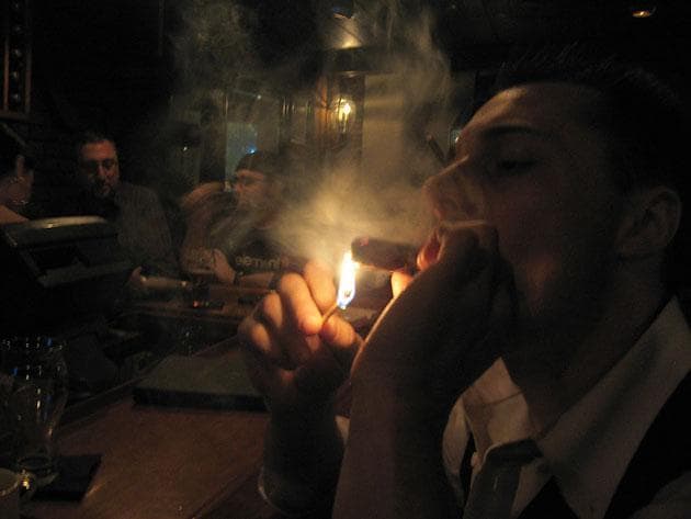 Joe Corrado, a 24-year-old bartender from Boston, is a regular customer at Cigar Masters in the Back Bay. (Karen Pelland for WBUR)