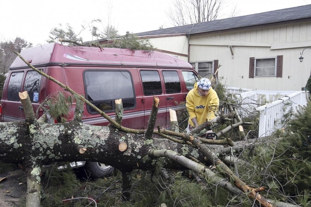 Luke Russell works on clearing a fallen tree in Farmington, N.H., Friday. (AP)