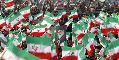 Female demonstrators wave Iranian flags, as a picture of supreme leader Ayatollah Ali Khamenei, is held at center, during an official rally commemorating the anniversary of the 1979 Islamic Revolution, at the Azadi Square in Tehran, Iran on Thursday, Feb. 11, 2010. (AP)