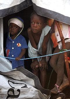 Children peer from their tent in a makeshift camp for earthquake survivors in Port-au-Prince, Thursday, Feb. 11, 2010. (AP)