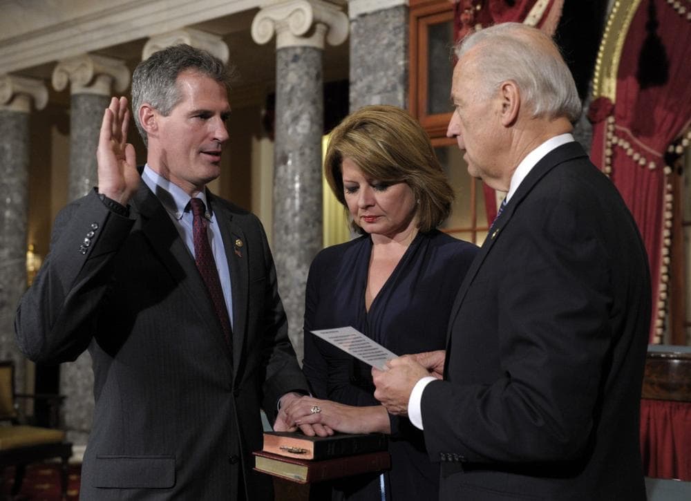 Sen. Scott Brown reenacts his swearing in by Vice President Joe Biden, right, as Brown's wife, Gail Huff, holds the family bibles Thursday in the Old Senate Chamber on Capitol Hill. Earlier, Brown was sworn in on the floor of the Senate. (AP)