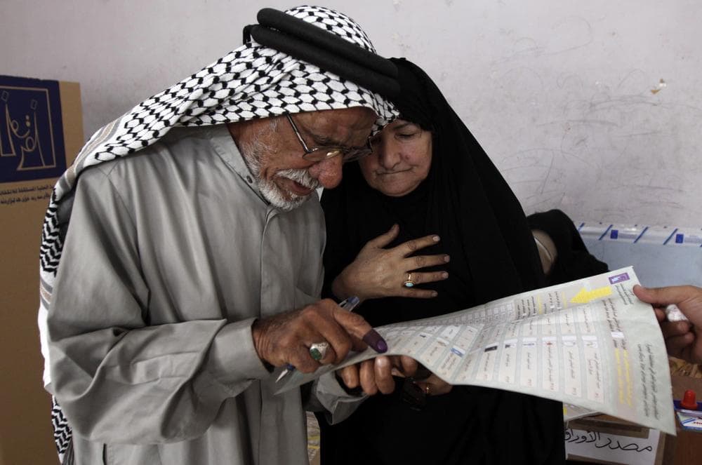 Jabbar Swaiyed, 72, and his wife look over a ballot before casting their vote in Basra, Iraq's second-largest city, 340 miles southeast of Baghdad, Iraq, Sunday. (AP Photo/Nabil al-Jurani)
