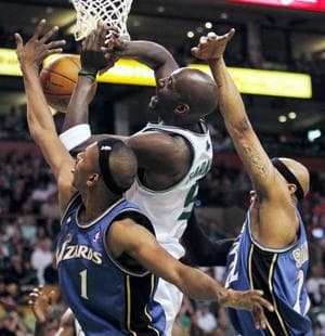Boston Celtics&#39; Kevin Garnett, center, has a shot blocked by Washington Wizards&#39; Nick Young, left, and James Singleton in the second quarter of Sunday&#39;s game. (AP Photo/Michael Dwyer)
