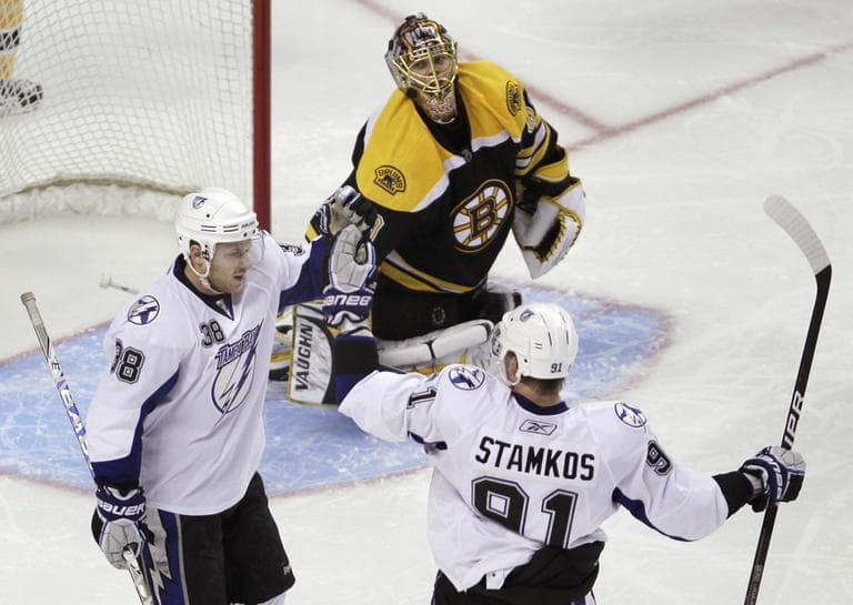 Boston Bruins goalie Tuukka Rask, center, of Finland, watches as Tampa Bay Lightning center Paul Szczechura, left, is congratulated by Steven Stamkos, right, after his third-period goal during Thursday's game. (AP Photo)