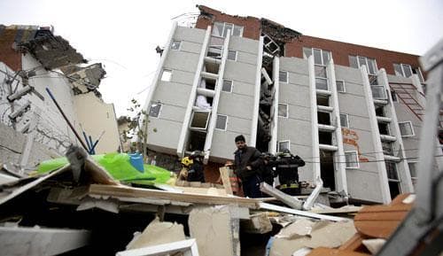 Relatives and firefighters search for people missing in Concepcion, Chile, on Sunday, Feb. 28, 2010, after an 8.8-magnitude earthquake that struck Chile early Saturday. (AP)