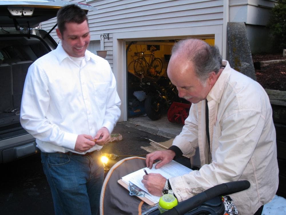 Joe Truschelli gets a signature from Chris Benning to get on the ballot in Plymouth. (Fred Thys/WBUR)