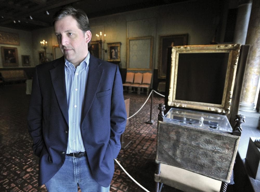 Anthony Amore stands beside empty frames from which the thieves took two of the paintings. (AP)